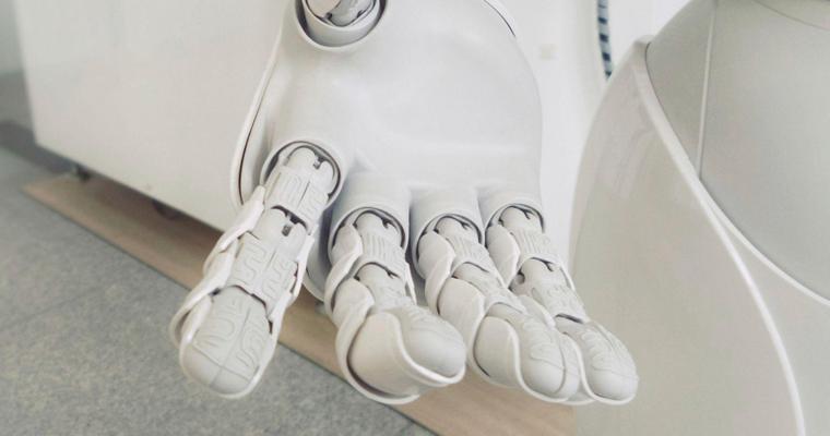 Eine Roboterhand eines weißen Roboters, der die Hand ausstreckt